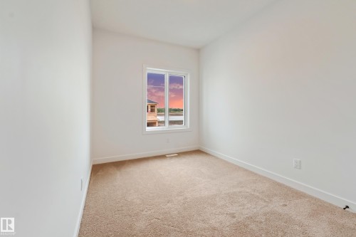Carpeted room with a single window and white trim - 4636 18 Avenue, Edmonton, AB 