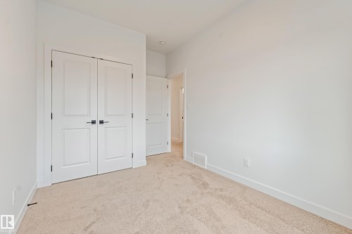 Neutral-toned carpeting paired with crisp white walls and baseboards - 4636 18 Avenue, Edmonton, AB 