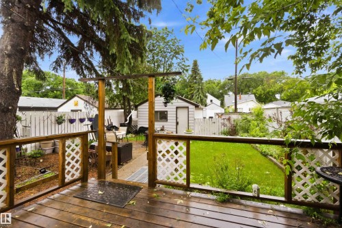 Spacious wooden deck with lattice railing overlooking a green lawn - 12016 61 Street, Edmonton, AB 