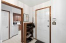 Entryway featuring a white paneled door with wood-finish trim, white walls, and a tiled floor - 12016 61 Street, Edmonton, AB 