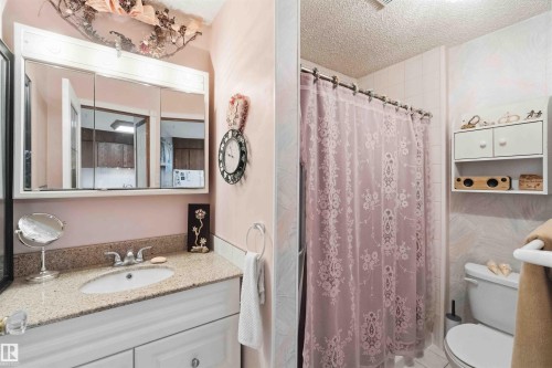 Bathroom featuring a white vanity with paneling, a light-toned speckled countertop, and a built-in medicine cabinet with mirrored doors - 12016 61 Street, Edmonton, AB 
