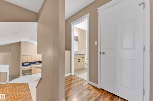 Hardwood-finish flooring extending into a bright hallway - 1328 80 Street, Edmonton, AB 
