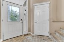 Entryway featuring a decorative glass panel door, an adjacent side light, a tiled floor, and a second panel door with a crown molding header - 1328 80 Street, Edmonton, AB 