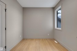 Light-filled room featuring wood-finish flooring and neutral gray walls - 