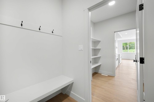 Mudroom entry with built-in bench, black coat hooks, and recessed lighting - 24 Grayson Green, Stony Plain, AB 