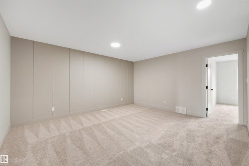 Spacious room featuring neutral carpeting, recessed ceiling lighting, and a board and batten accent wall - 24 Grayson Green, Stony Plain, AB 