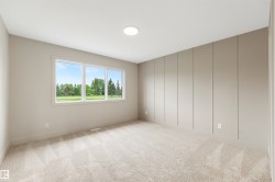 Expansive room featuring a large three-panel window, light-toned carpet flooring, a decorative panel accent wall, and recessed ceiling lighting - 