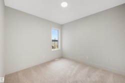 Neutral tone painted walls with a single window and recessed ceiling lighting - 