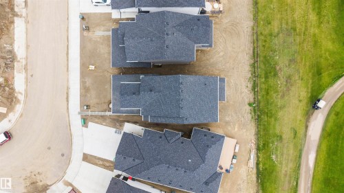 Aerial perspective showcasing properties with dark asphalt shingle roofing - 24 Grayson Green, Stony Plain, AB 