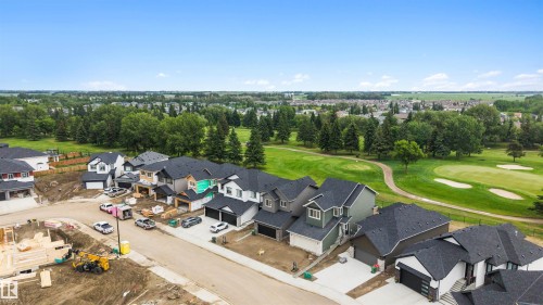 Residential development featuring new construction homes alongside a golf course with mature trees - 24 Grayson Green, Stony Plain, AB 