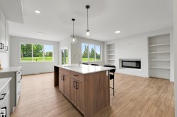 Open-concept living area featuring a kitchen island with built-in cabinetry, quartz countertops, and a stainless steel sink - 