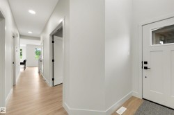 Light wood-finish flooring extending through the hallway - 
