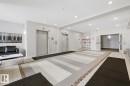 Lobby area featuring two elevators, recessed lighting, and a patterned tile floor with decorative border - 155 1818 Rutherford Road, Edmonton, AB 