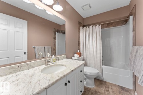 Bathroom vanity with a speckled countertop, undermount sink, and brushed nickel faucet - 2602 Delta Road, Cold Lake, AB 