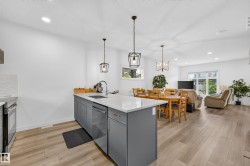 Modern kitchen island featuring a white countertop, undermount sink with gooseneck faucet, and gray cabinetry - 