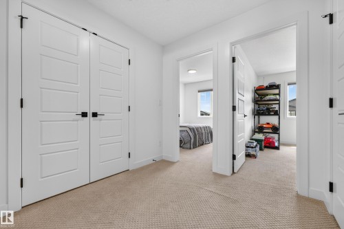 White paneled doors with black hardware, neutral carpeting, and white walls - 104 Kidd Crescent, Leduc, AB 