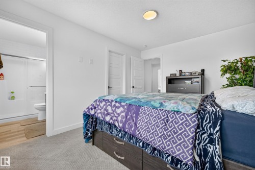 Carpeted bedroom with a flat white ceiling and a flush-mount light fixture - 104 Kidd Crescent, Leduc, AB 