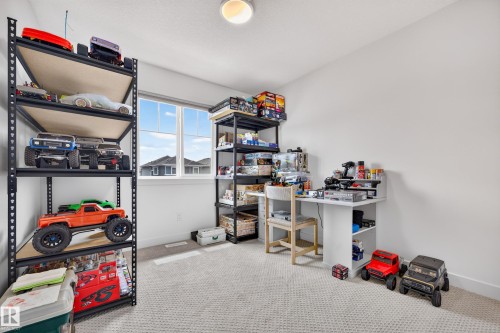 Carpeted room with a double-pane window, white walls, and a ceiling light fixture - 104 Kidd Crescent, Leduc, AB 