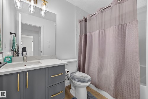 Bathroom featuring a single vanity with gray cabinetry, gold-toned hardware, and a white countertop - 104 Kidd Crescent, Leduc, AB 