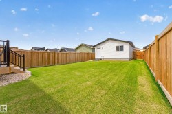 Expansive green lawn surrounded by privacy fencing - 