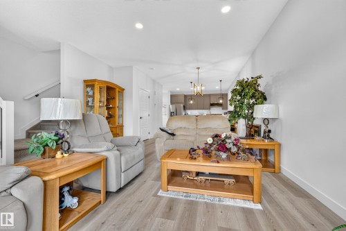 Open-concept living space featuring wood-finish flooring and recessed ceiling lights - 104 Kidd Crescent, Leduc, AB 