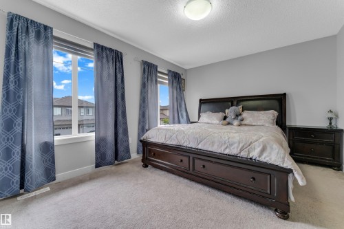 Carpeted room with multiple windows providing natural light - 1750 27 Street, Edmonton, AB 