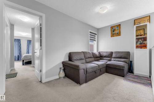Carpeted room with light gray walls, featuring a window with horizontal blinds and a built-in white display cabinet - 1750 27 Street, Edmonton, AB 