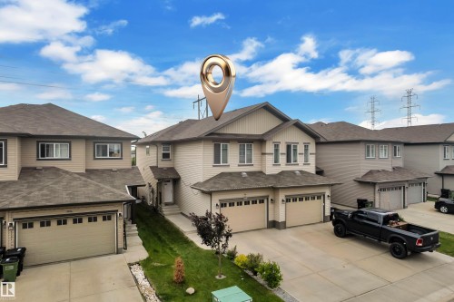 Two-story residence featuring light-colored siding, a dark shingle roof, and a two-car attached garage - 1750 27 Street, Edmonton, AB 