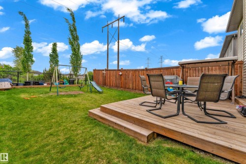 Expansive backyard featuring a multi-level wood deck, manicured lawn, and privacy fencing - 1750 27 Street, Edmonton, AB 