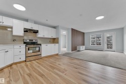 Open-concept living space with wood-finish flooring transitioning to carpeting - 