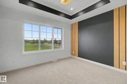 Expansive window showcasing exterior scenery, complemented by a modern accent wall with vertical wood paneling and a contrasting dark finish - 