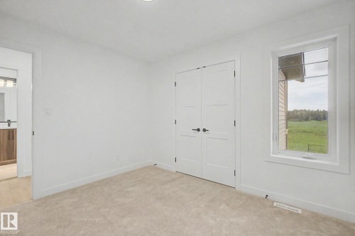 Bedroom featuring neutral carpeting, white walls, and a window with white trim - 4 Willow Heights Drive, Stony Plain, AB 