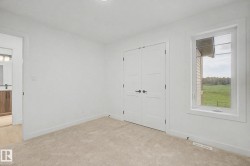 Bedroom featuring neutral carpeting, white walls, and a window with white trim - 