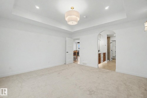 Spacious room featuring light-colored carpeting and a tray ceiling with recessed lighting - 4 Willow Heights Drive, Stony Plain, AB 