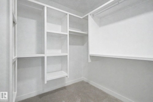Custom built-in closet system featuring white shelving and hanging rods - 4 Willow Heights Drive, Stony Plain, AB 