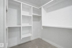Custom built-in closet system featuring white shelving and hanging rods - 