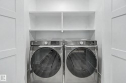 Dedicated laundry area featuring a front-loading washer and dryer set - 
