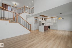 Open-concept living space with light wood-finish flooring - 