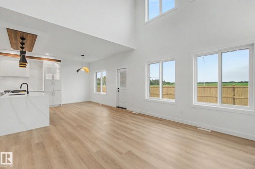 Spacious open-concept living area featuring high ceilings, wood-finish flooring, and multiple large windows - 4 Willow Heights Drive, Stony Plain, AB 