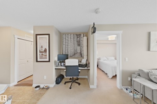 Built-in desk area featuring a floating shelf and accent wall, neutral tone walls, and white trim throughout - 117 3715 Whitelaw Lane, Edmonton, AB 