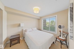 Bedroom featuring a large window with white blinds, neutral-toned walls, and carpet flooring - 