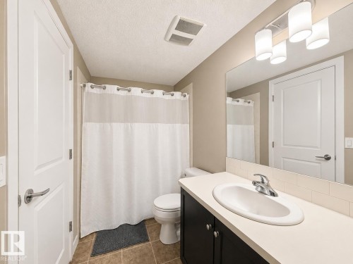 Bathroom vanity featuring a single basin sink, chrome faucet, and dark wood cabinetry - 117 3715 Whitelaw Lane, Edmonton, AB 