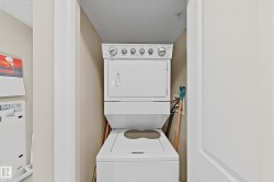 Dedicated laundry area featuring a white stacked washer and dryer unit - 