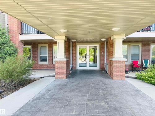 Brick facade with a covered entrance featuring stamped concrete paving - 117 3715 Whitelaw Lane, Edmonton, AB 