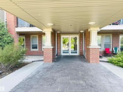 Brick facade with a covered entrance featuring stamped concrete paving - 