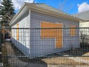Detached structure featuring light gray horizontal siding and a dark shingle roof - 11406 88 Street, Edmonton, AB 