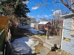 Expansive backyard featuring a detached garage, wooden privacy fencing, and a multi-level wooden deck - 