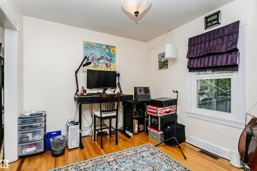 Hardwood flooring throughout, featuring an interior window with trim and a ceiling-mounted light fixture - 11105 81 Avenue, Edmonton, AB 