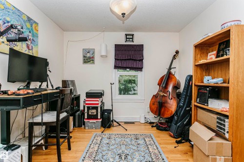 Bright room featuring wood-finish flooring and a central ceiling light fixture - 11105 81 Avenue, Edmonton, AB 