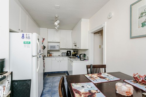 Galley kitchen with white cabinetry and a built-in microwave - 11105 81 Avenue, Edmonton, AB 